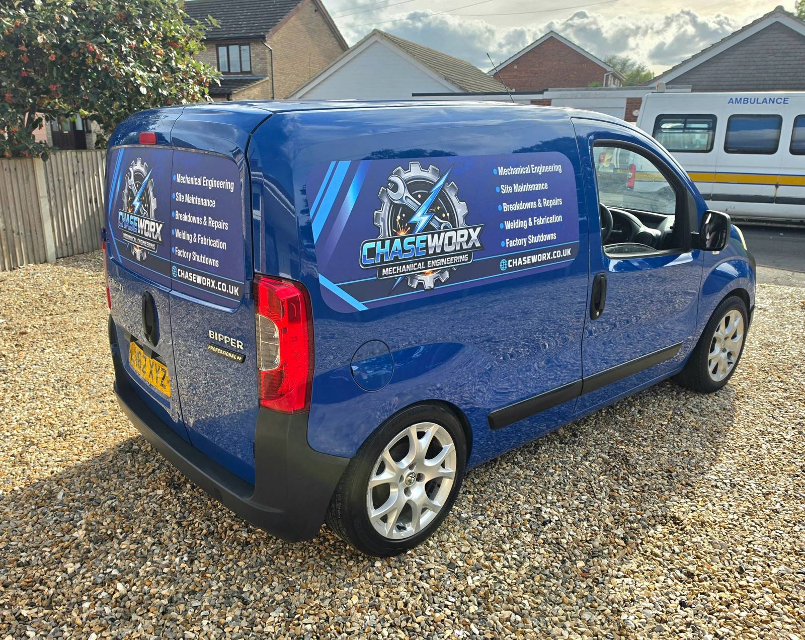 Blue service van with Chaseworx signage parked on gravel.