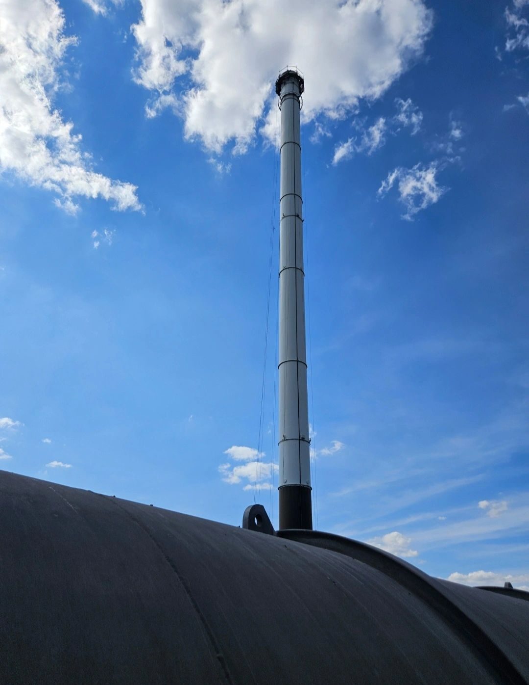 Tall steel chimney stack against a blue sky