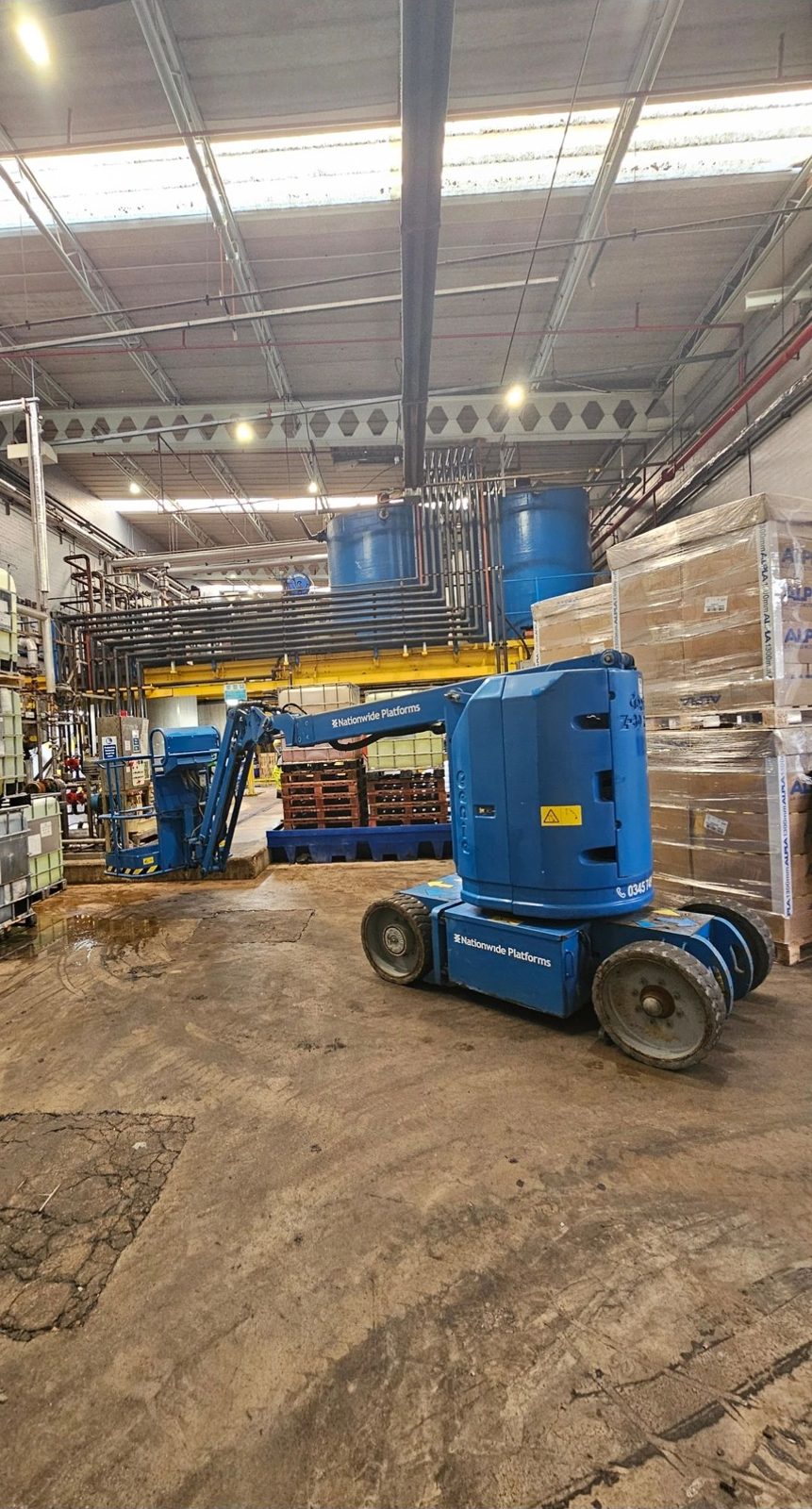 Blue access platform lift inside a factory unit