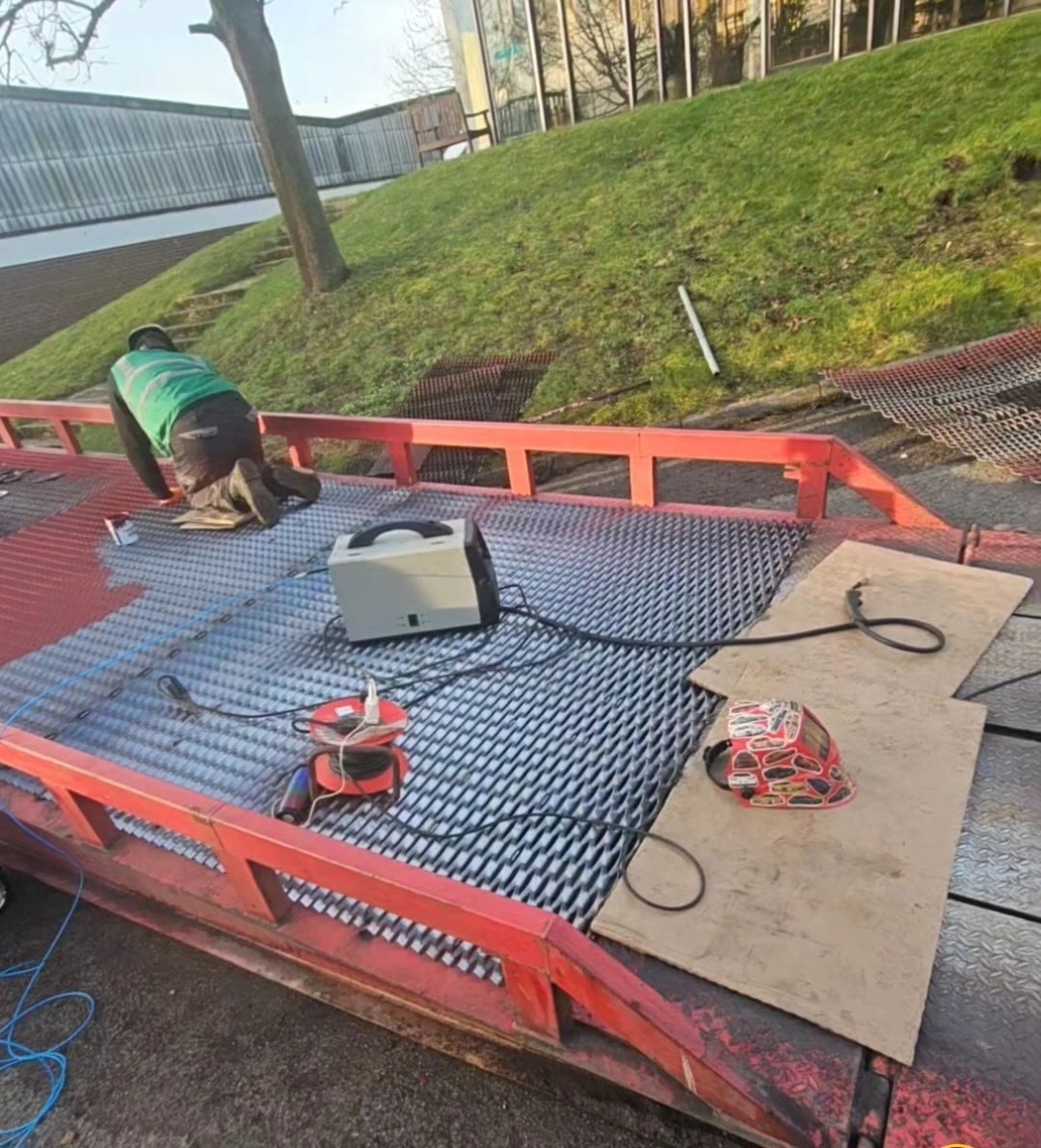 Welding kit laid out on a red loading ramp during repair
